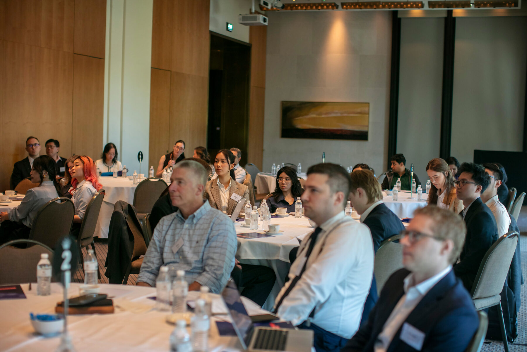 Participants seated at round tables during the Melbourne Forum